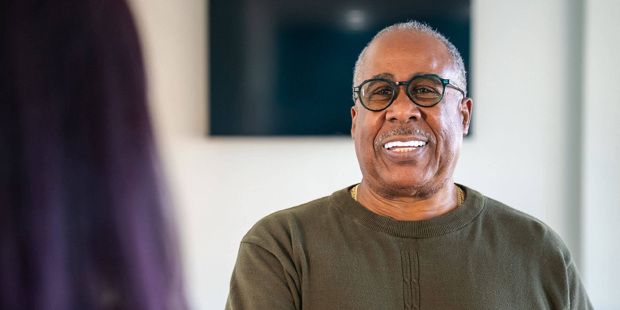 patient smiling brightly while being helped at the front desk of the dental center
