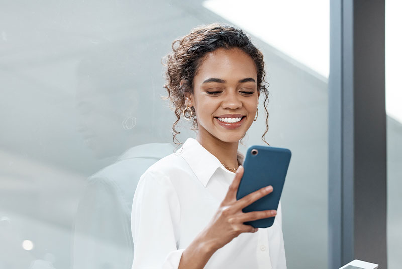 young female smiling brightly while talking on the phone