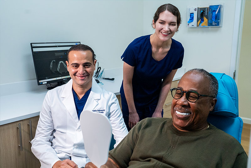 patient and doctor and staff member smiling after patient's dental procedure