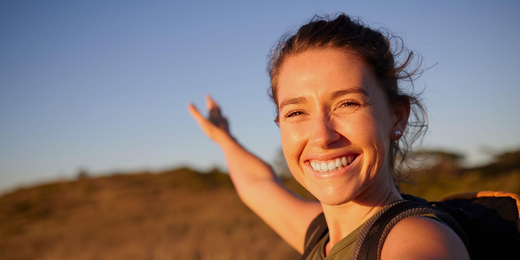 young women smiling brightly while hiking outside in the great outdoors