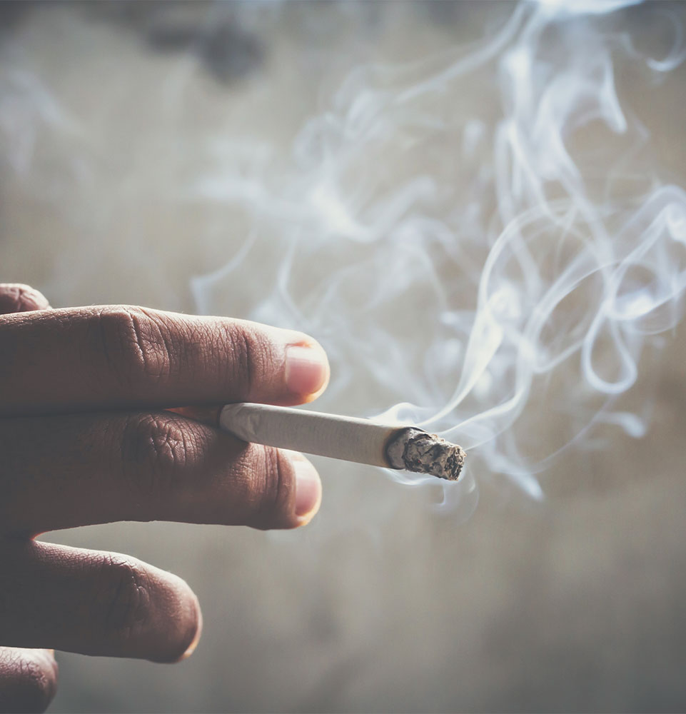 close up of person smiling a cigarette