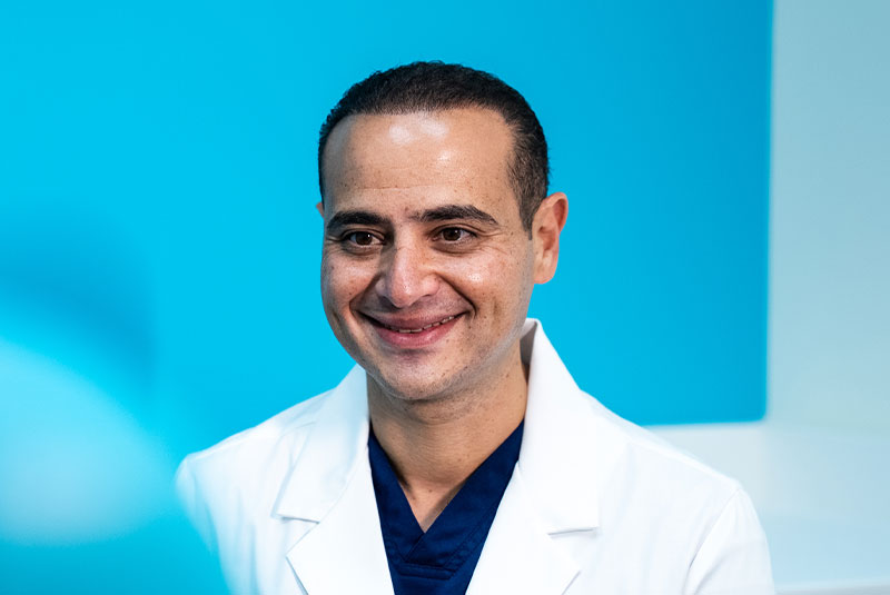 headshot of doctor smiling brightly while talking to patient