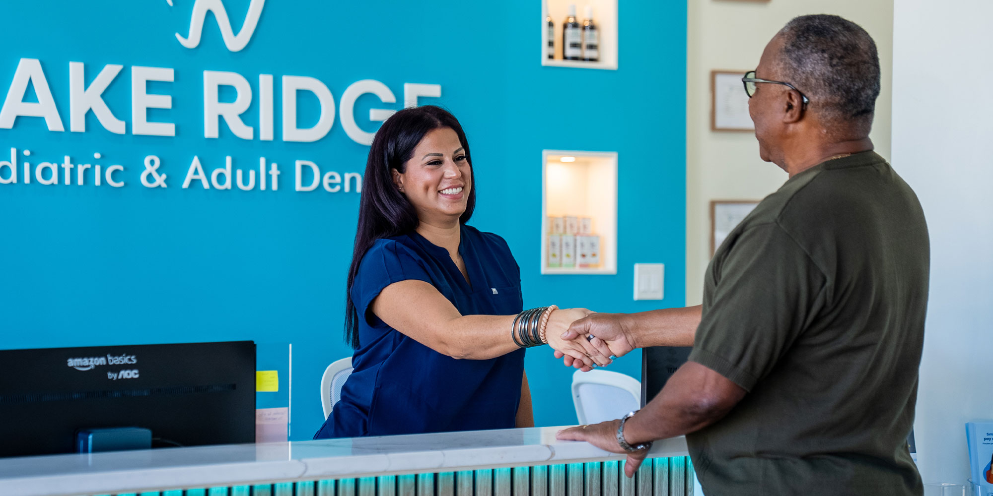 staff member helping patient at the front desk for he dental center