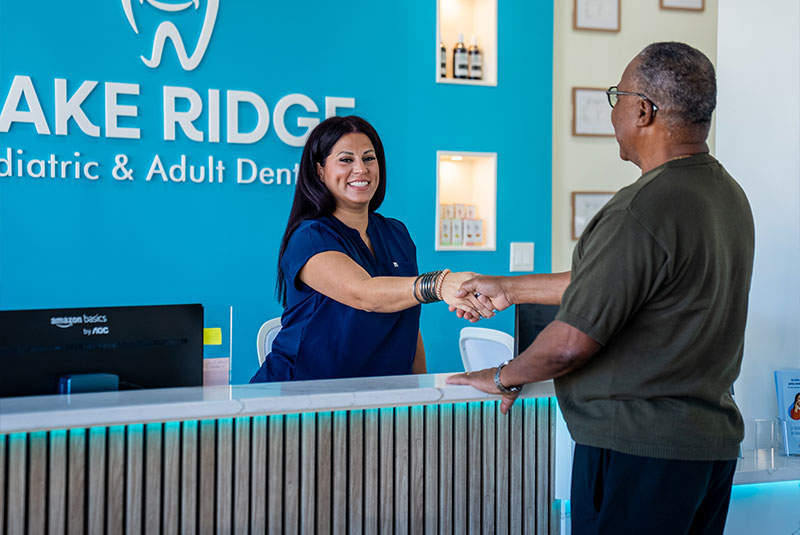 staff member helping patient at the front desk for he dental center